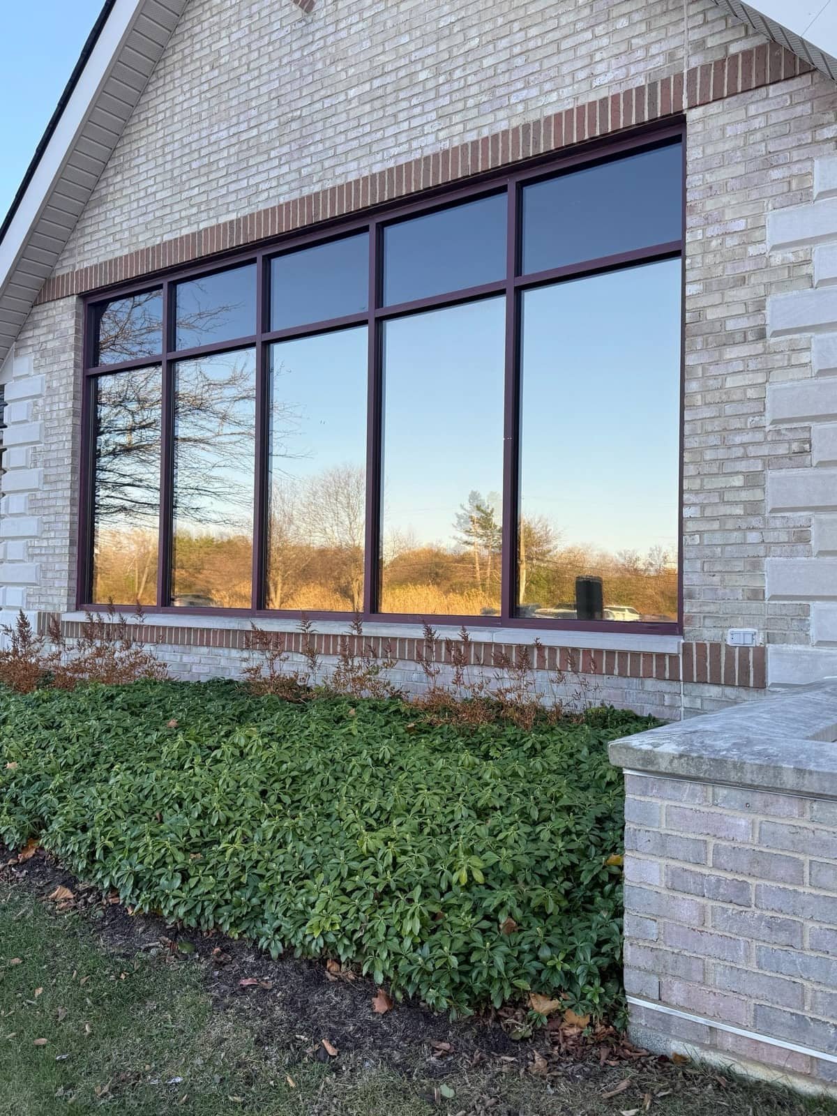 Commercial building with mirrored solar-control film reflecting an Ontario sunset